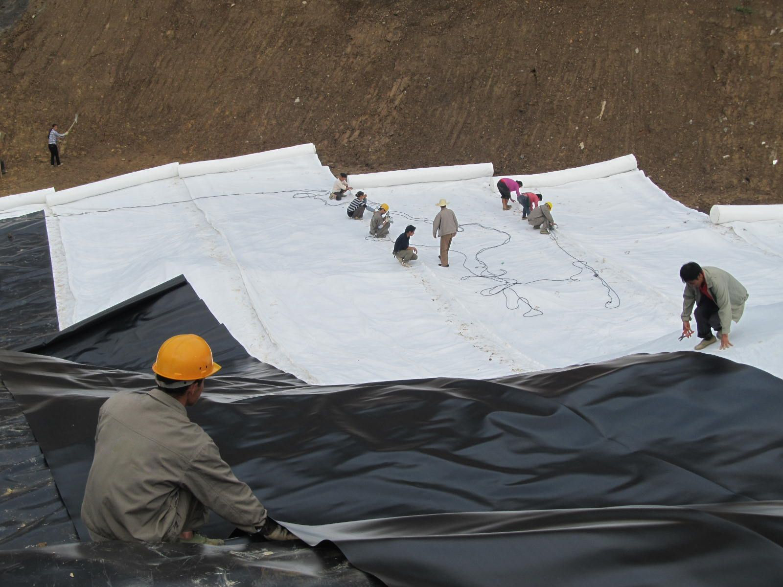 尾矿库坝坡土工膜多人铺设施工实景